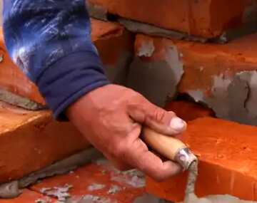 FX №50273 worker builds a wall of bricks. the builder on a building makes bricklaying.