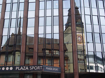 In glass facade of the modern home reflects the old town hall with clock №422