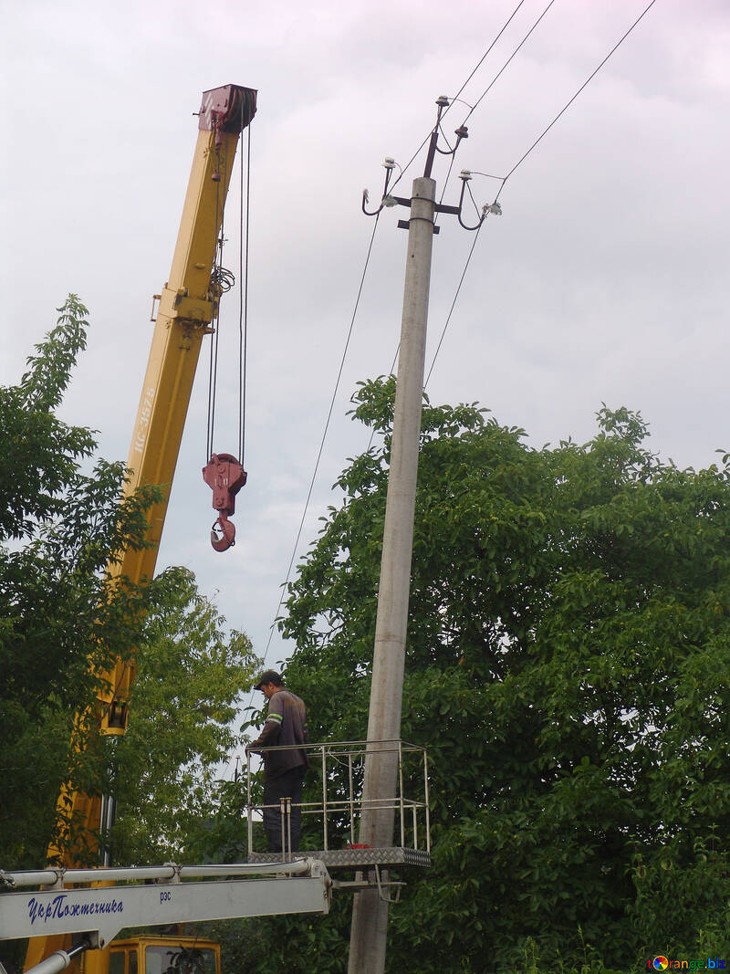 The electrician in cradle rises for repair of high-voltage column №607