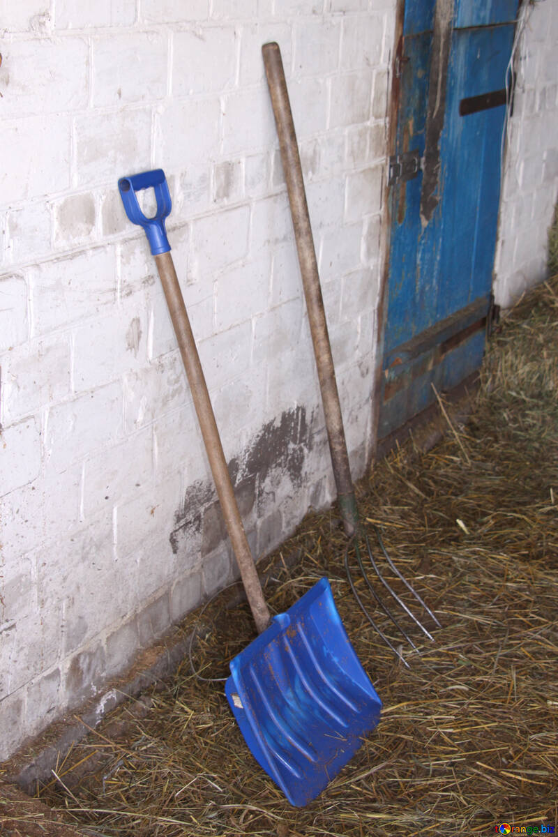 Bêche et fourche sur le fond de murs en briques blanchies à la chaux №698