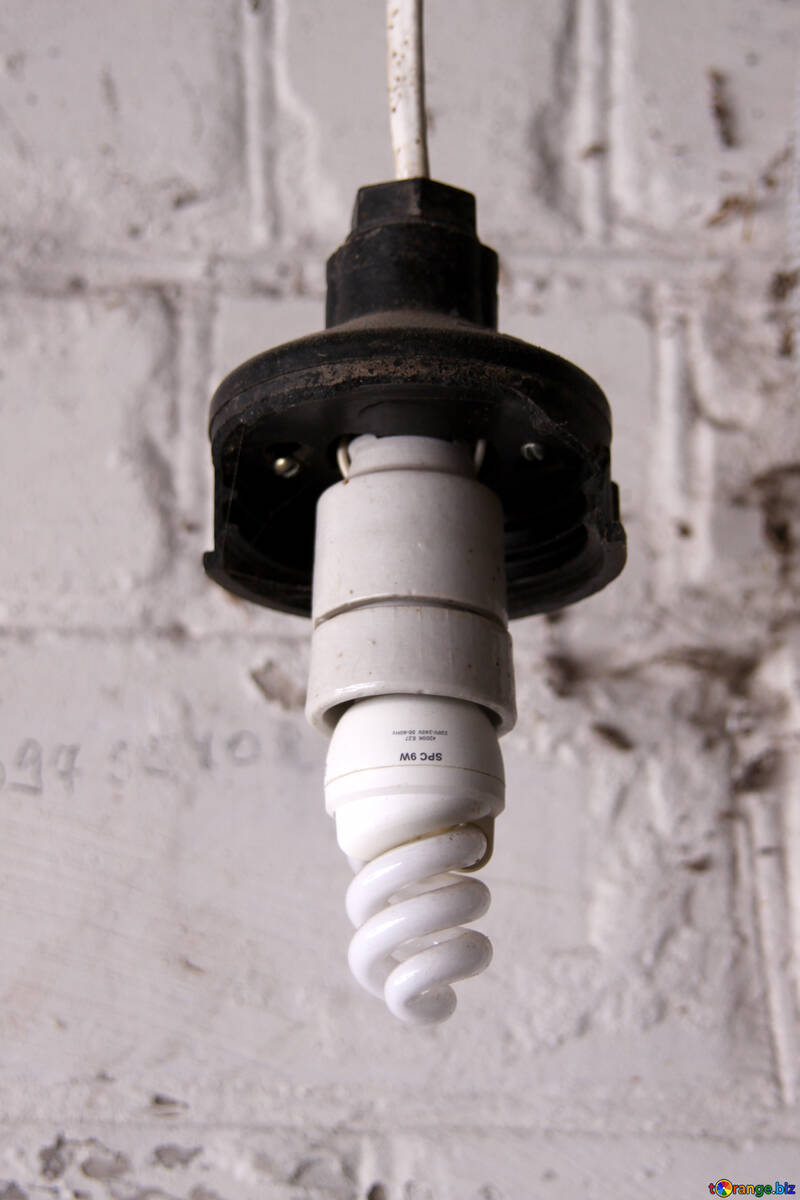 Енергозберігаюча лампа в старому патроні на тлі цегляної стіни №508