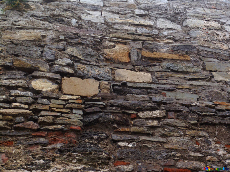 Ancient stone wall made of different materials with traces of frequent repair №358