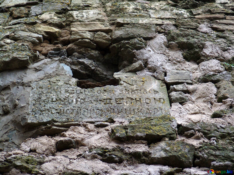  dilapidadas tablilla de piedra con una inscripción en las ruinas de una antigua muralla del castillo de placa piedras de mampostería de piedra  №360