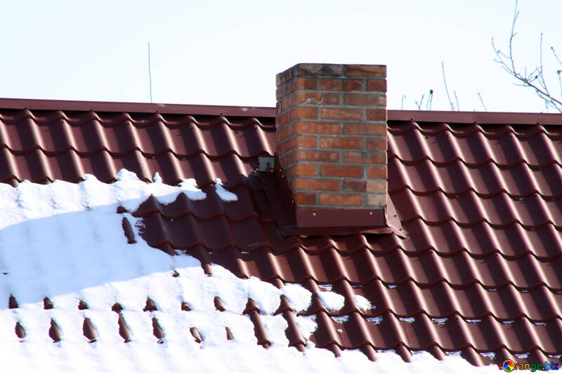 Brick chimney flue in the roof in winter metallocherepichnoy №497