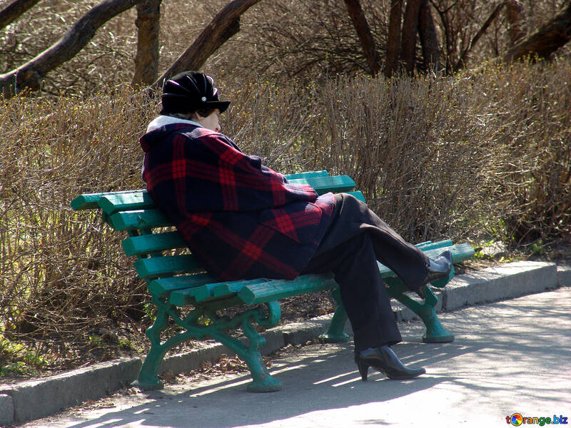  Una mujer que relajaba en un parque en un banco de la mujer  №1449