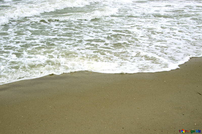 Eine Welle wäscht Fußspuren im sand №12738