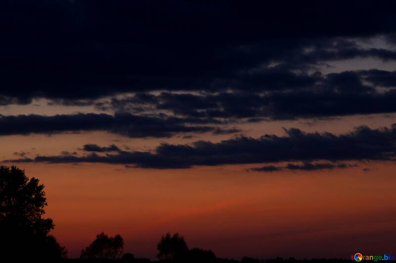 Cielo arancione con le nubi scure al tramonto №2400