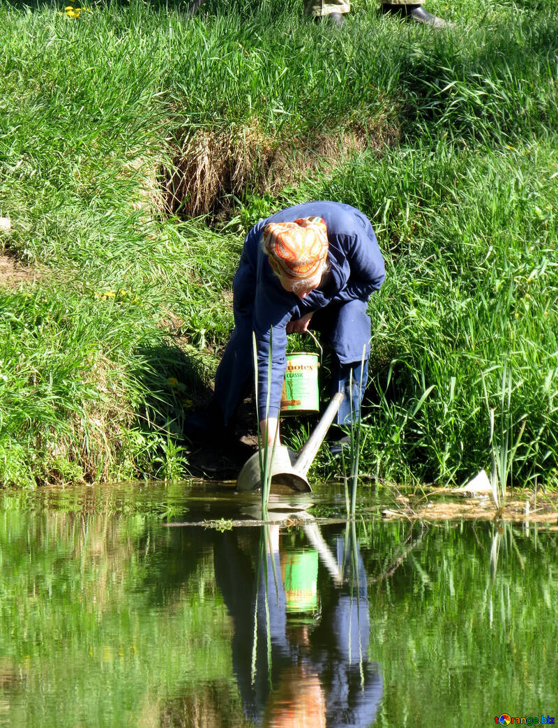 Frau sammelt Wasser aus dem See №26577