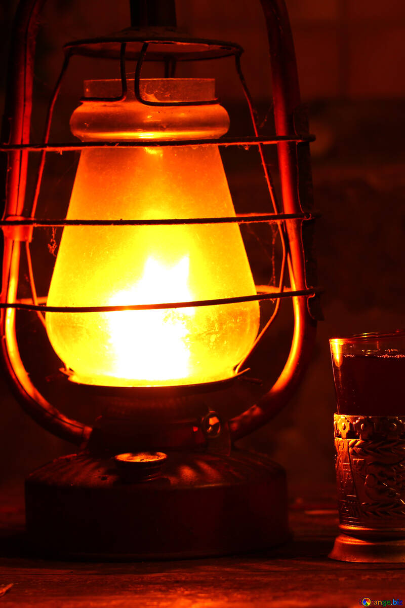 A kerosene lamp and cup of tea on the table №33914
