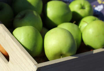 Green apples in a wooden box