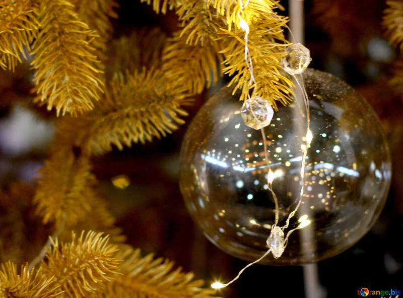 Brinquedo do Natal transparente sobre uma árvore de Natal com lâmpadas №47774