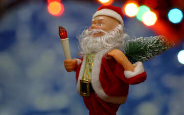 Nueva tarjeta con el juguete del `s de Santa Claus trae árbol de Navidad en suave resplandor azul de fondo bokeh y luces borrosa en primer plano. <font>concepto contexto para la bandera de mercado, cartel, tarjeta de felicitación.</font> №48154
