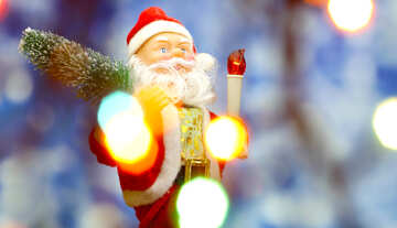 Nueva tarjeta con el juguete del `s de Santa Claus trae árbol de Navidad en suave resplandor azul de fondo bokeh y luces borrosa en primer plano. <font>concepto contexto para la bandera de mercado, cartel, tarjeta de felicitación.</font> №48158