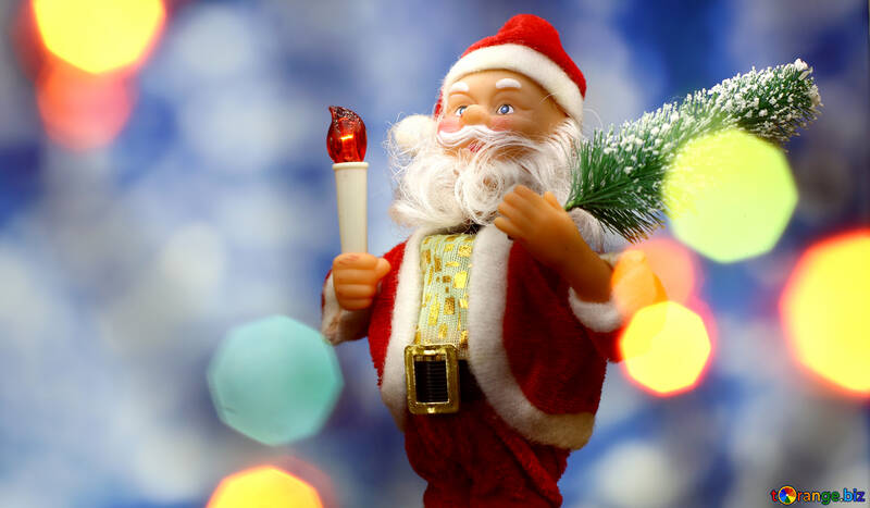 Santa Claus toy brings Christmas tree at blue snowy night bokeh background and blurred lights foreground. Red lantern torch to light the way. Big Copyspace concept New Year`s market banner, poster. №48163