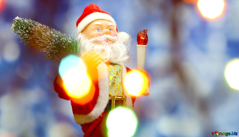 New Year`s card with Santa Claus toy brings Christmas tree at glow soft blue bokeh background and blurred lights foreground. Copyspace concept for market banner, poster, congratulations card. №48158