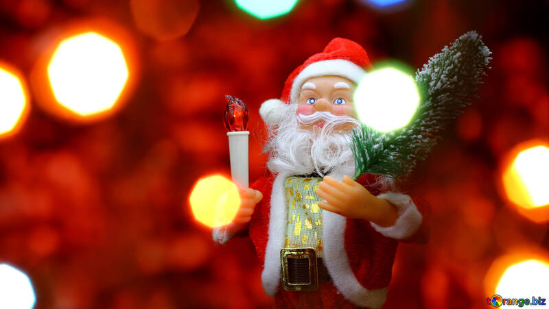 Santa Claus toy brings Christmas tree at glow red bokeh background and blurred lights foreground.  №48171