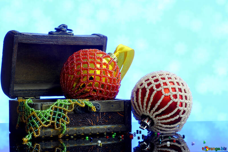 Новорічні кульки прикрашені бісером в дерев`яній скриньці на розмитому фоні №48054