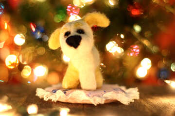 Symbol of new years 2018 yellow dog. New years greetings background. Fancy handmade toy from wool on bokeh Christmas background. Place for insert logo or write text. Copyspace for congratulations.