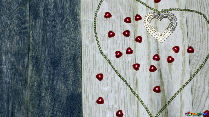 Червоні сердечка цукерки, оточені зеленим контуром на дерев`яному тлі №49234