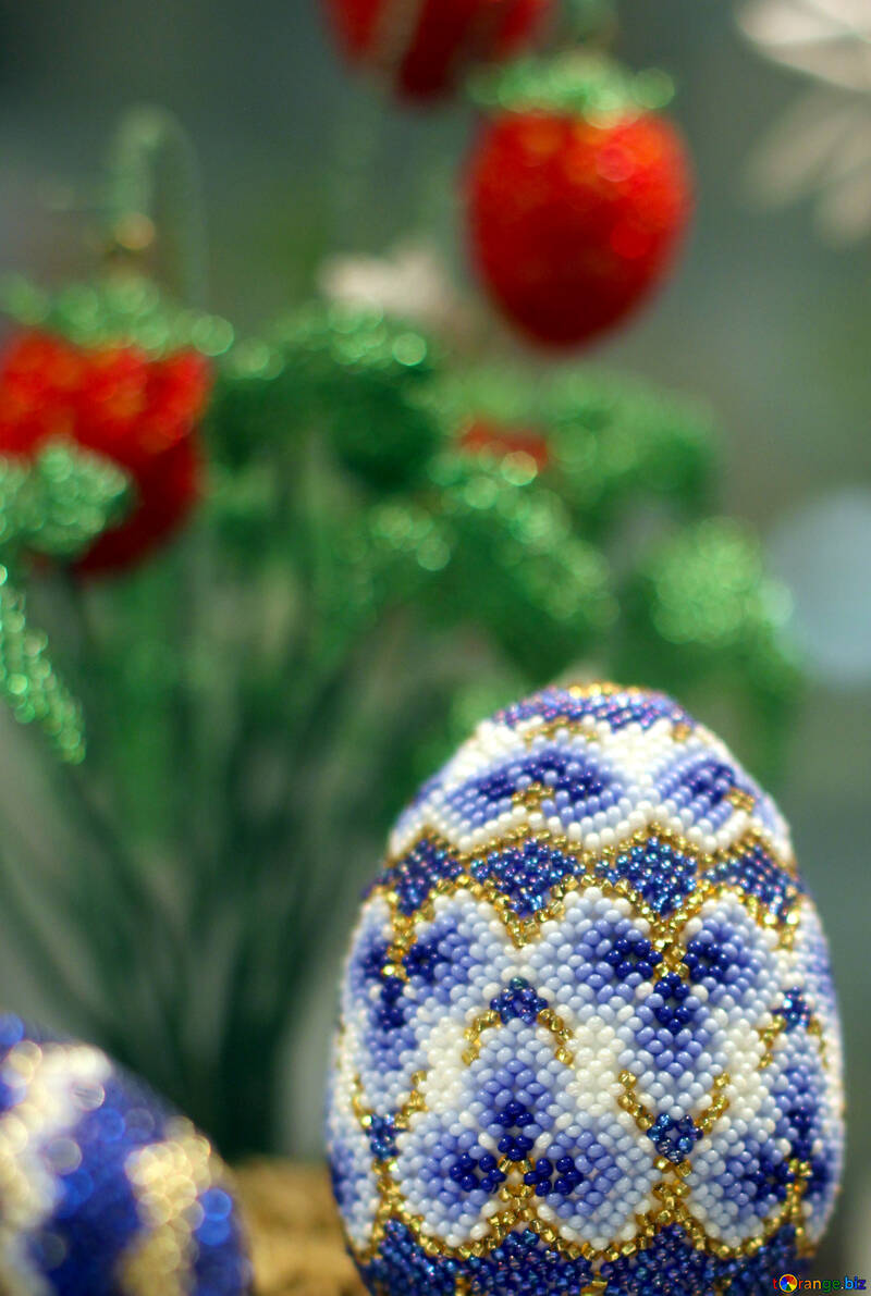 Easter egg decorated with beads on the background of flowers №49164