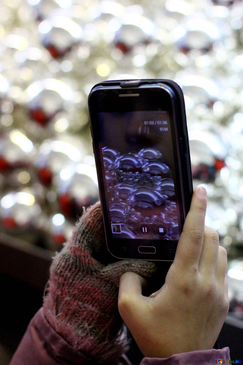 Manos sosteniendo el teléfono en el fondo de decoraciones de Navidad №49479