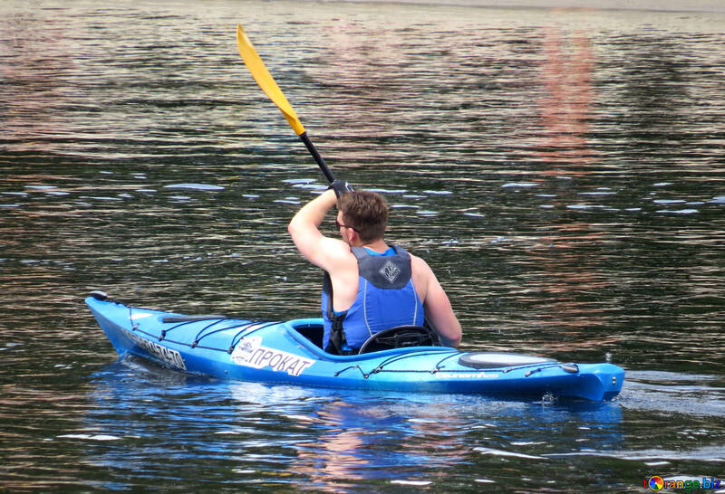 Ein Mann schwimmt entlang eines Flusses in einem Boot mit Rudern №49916