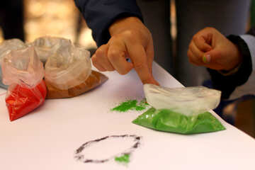 Manos metiendo la mano en una bolsa de verde haciendo decoraciones dedos dedos. №51069