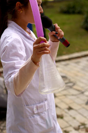 Mujer en bata de laboratorio con vaso y micrófono chica con micrófono №51027
