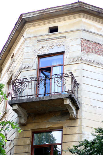 Ein hellbraunes Haus mit einem Fenster und einem Balkon, mit einem flachen Dach №51741