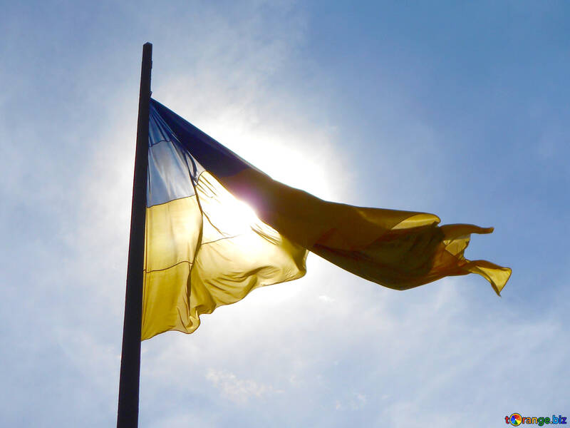 La bandiera dell`Ucraina con il sole dietro di esso le piccole nuvole il è giallo e blu №51273
