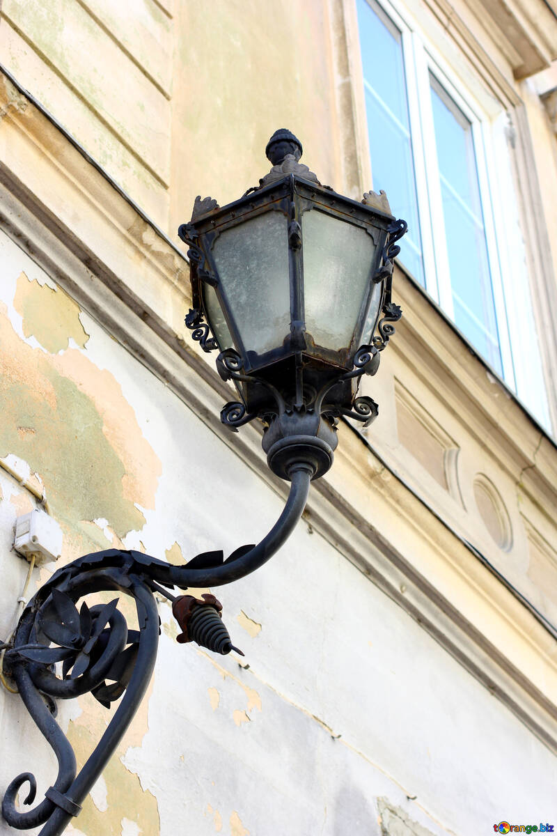 An old-fashioned style of lamp mounted on a wall with a window above №51645