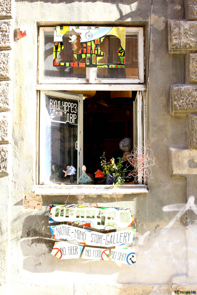 Ein offenes Fenster mit Blumen im Fensterbrett und ein Bild darüber №51675