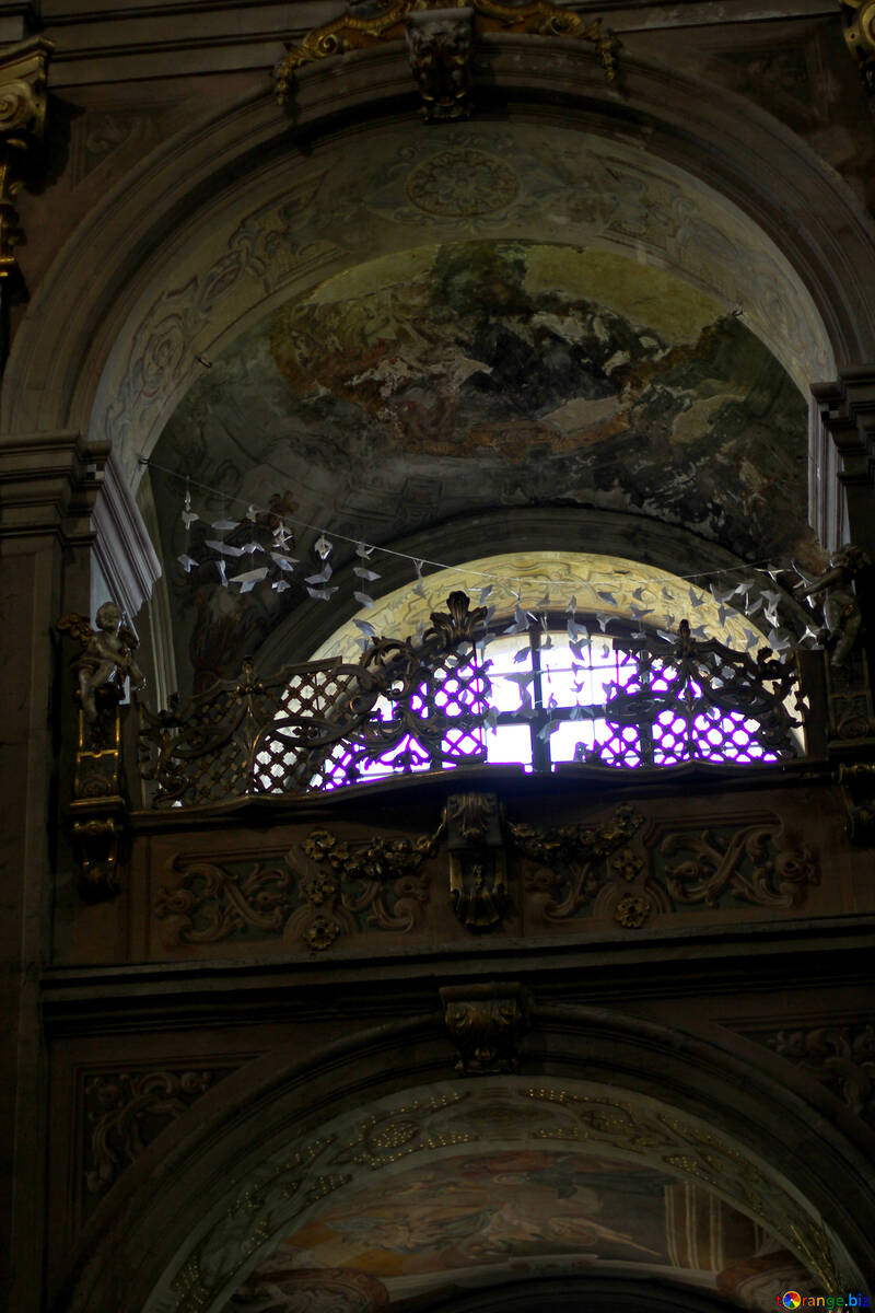 There is a bright light coming out of a stained glass window, this looks like a church. №51869