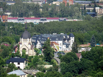 周囲の家々が建ち並ぶ建物と木々が並ぶ城教会 №52116
