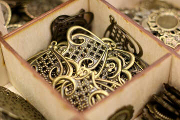 Коробка, наповнена блискучими латунними орнаментами, металевими прикрасами, золотими речами №52767