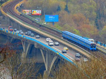 a highway many cars and a train on the side bridge yellow blue line traffic road №52421