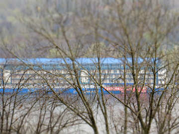 Ein Lastkahn auf einem Kanal, versteckt von Ästen, Gebäude am Kanal mit Bäumen im Vordergrund №52436