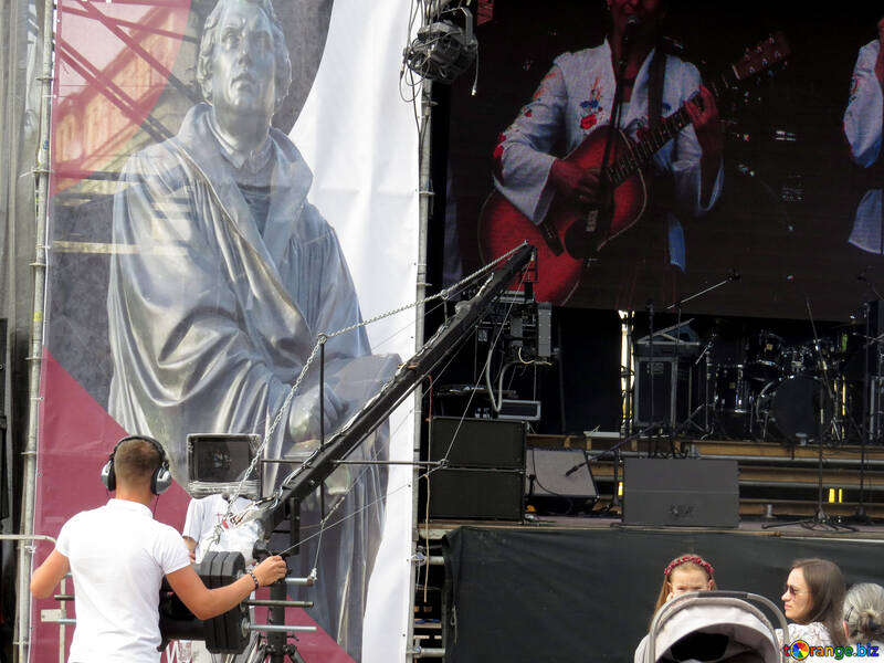 Konzert neben dem Bild des Statue-Kameramanns und des Gitarristenmannes, der Gitarre spielt №52280