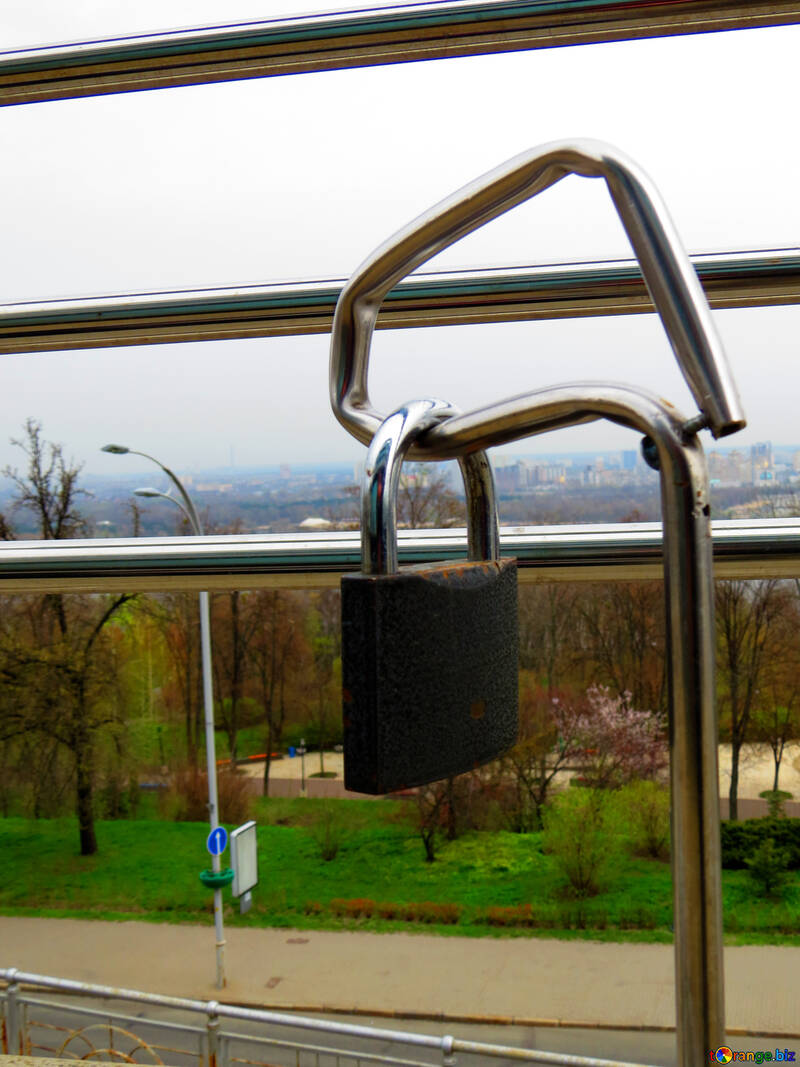 A lock on a window with the view of a city in the background padlock locker №52430