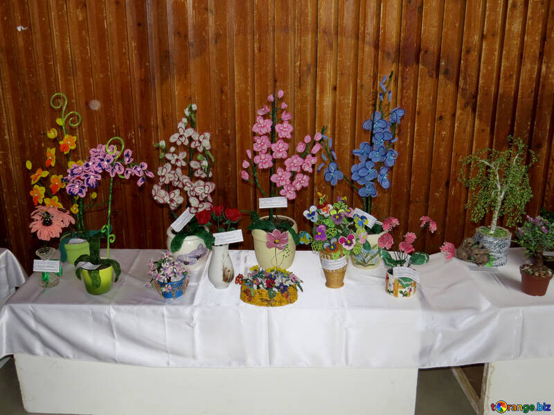 Handgemachte Blumen auf einer weißen Tischdecke mit einem Holztafelhintergrund №52387