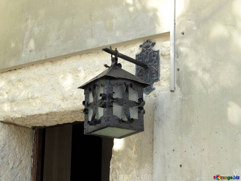Uma lanterna sobre uma porta na tocha de parede branca №52313