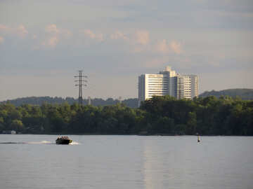 森と背の高い建物の横にあるバックボート湖の建物と川 №53442