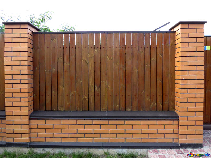 Brown fence in between two brick walls bricks gate №53434