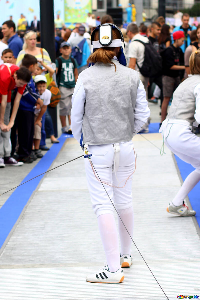Girl wearing white Adidas shoes seemingly performing in front of an audience fencing №53989