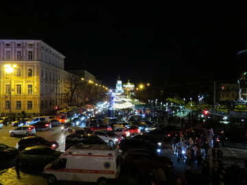 buildings with cars and people in a lit street at night lights of city №54107