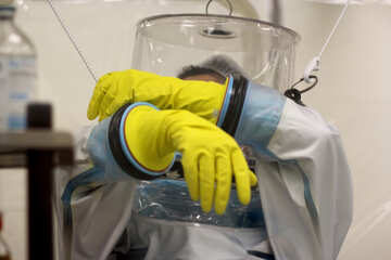 person covered in protective gear wearing yellow gloves hazmat siut №54627