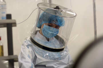 person wearing scrubs and a plastic vacuum helmet scientist with mask hood covid patient quarantine protective docotr  lady №54596