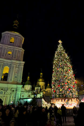 Weihnachtsturm-Kirche mit einem Weihnachtsbaum und Leuten um ihn №54079