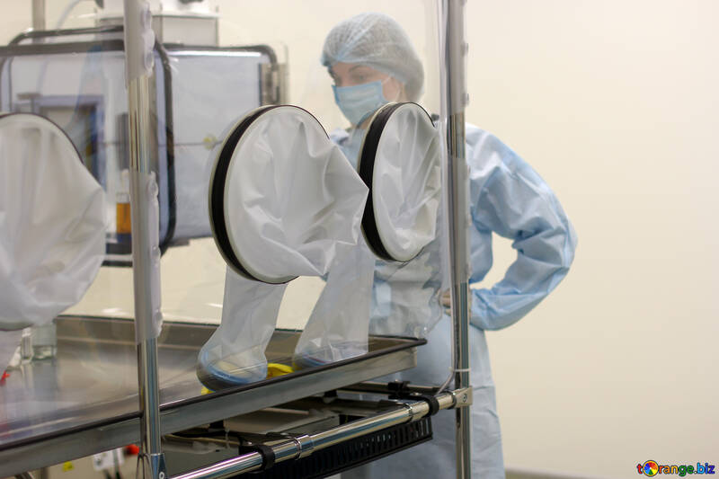 Personas con equipo médico experimentando en un entorno estéril Equipo de investigación de caja hermética de laboratorio médico №54631