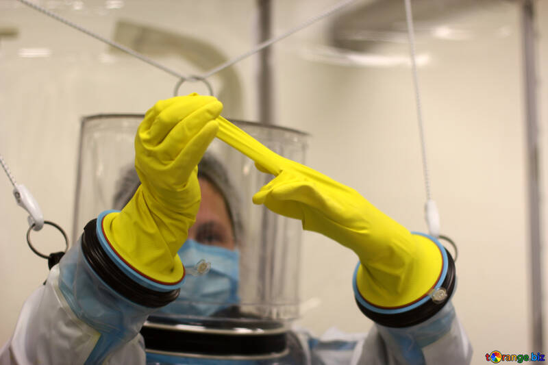 Жінка із захисним костюмом розмовляє рукавицею з лікарських рукавичок Biohazard Yellow №54628